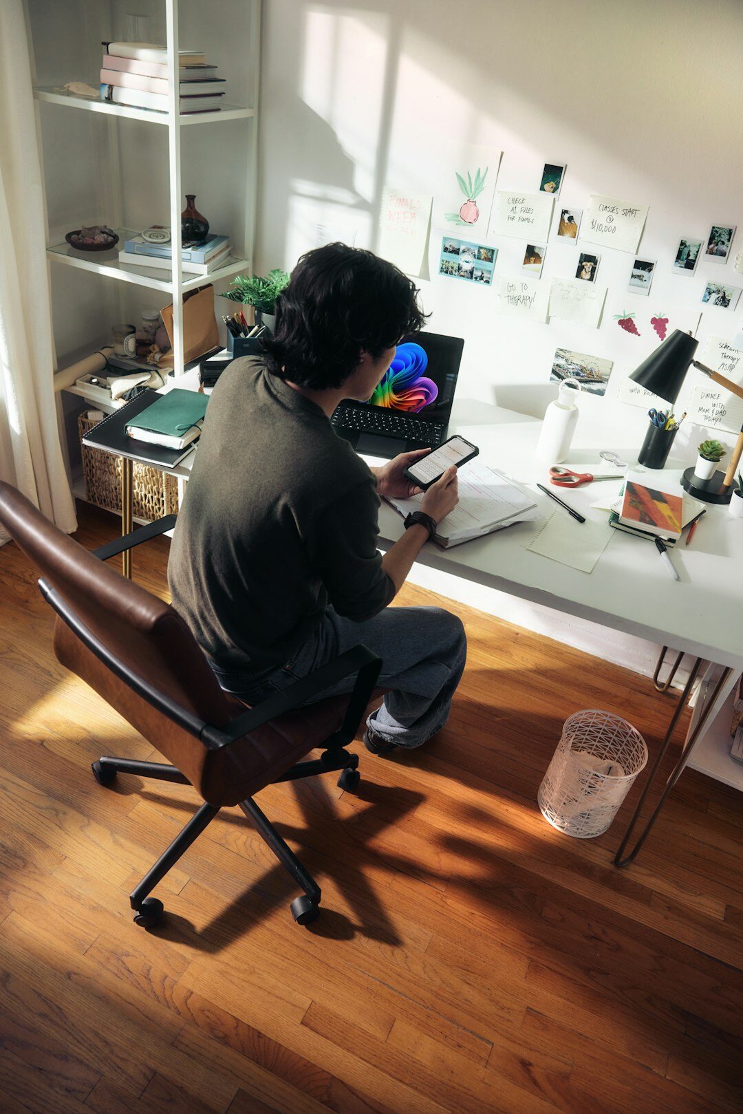 Editor working at a desk reviewing photographs on a laptop